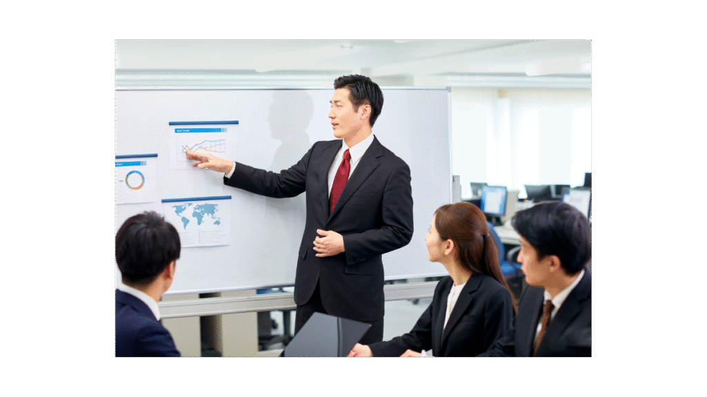 A Man at a white board organising staff members