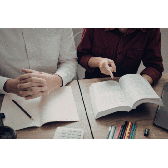 Two students reading from a text book